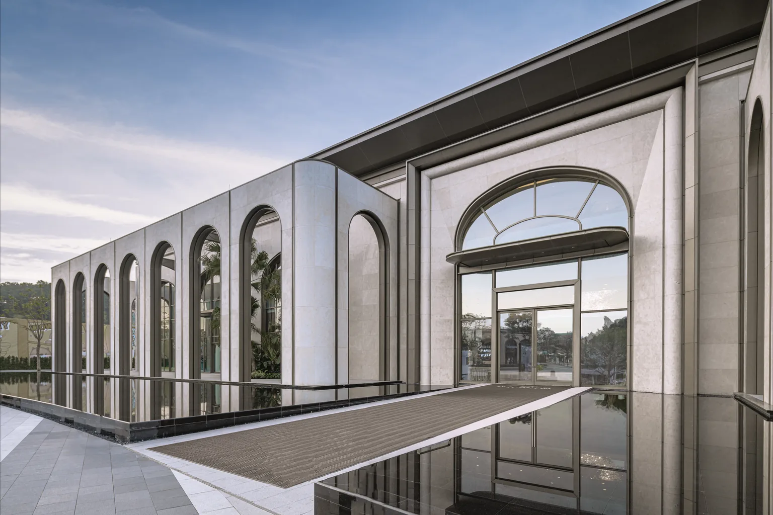 Completed building exterior showing coordinated stone facade arched glazing and entrance systems