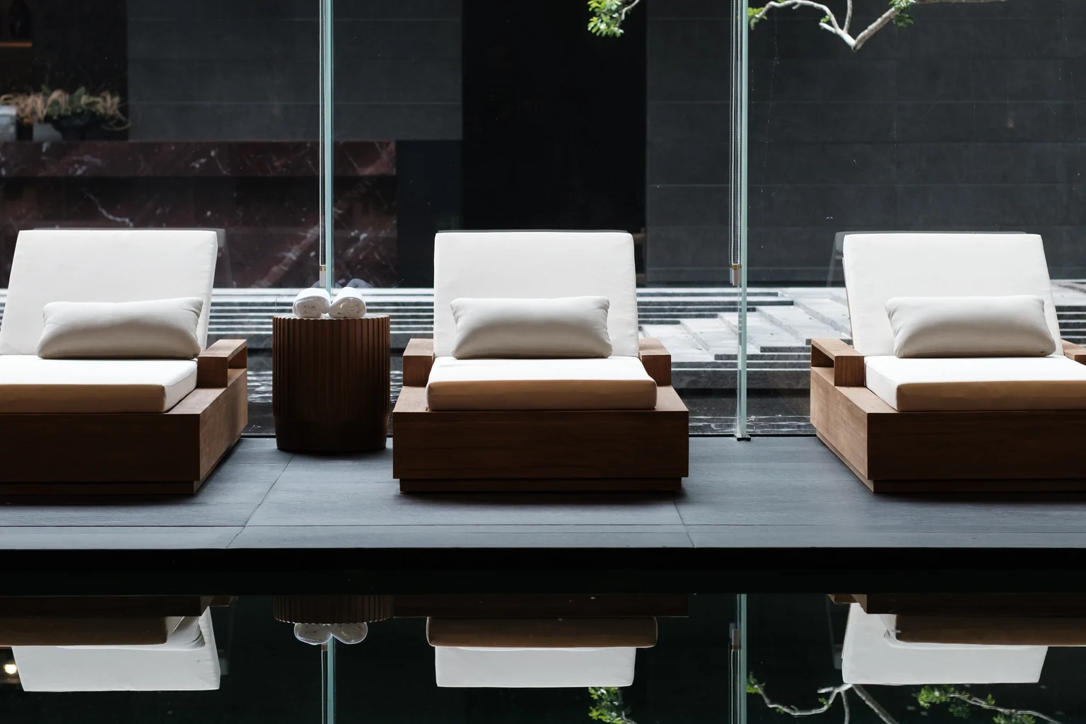 Poolside loungers beside a reflective indoor pool in Dubai