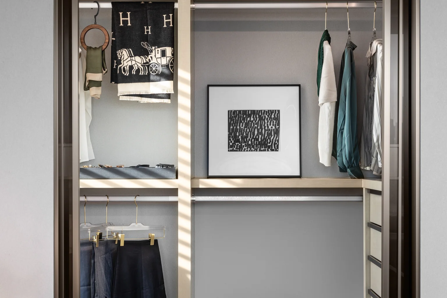 Walk-in closet with illuminated display storage and integrated drawers