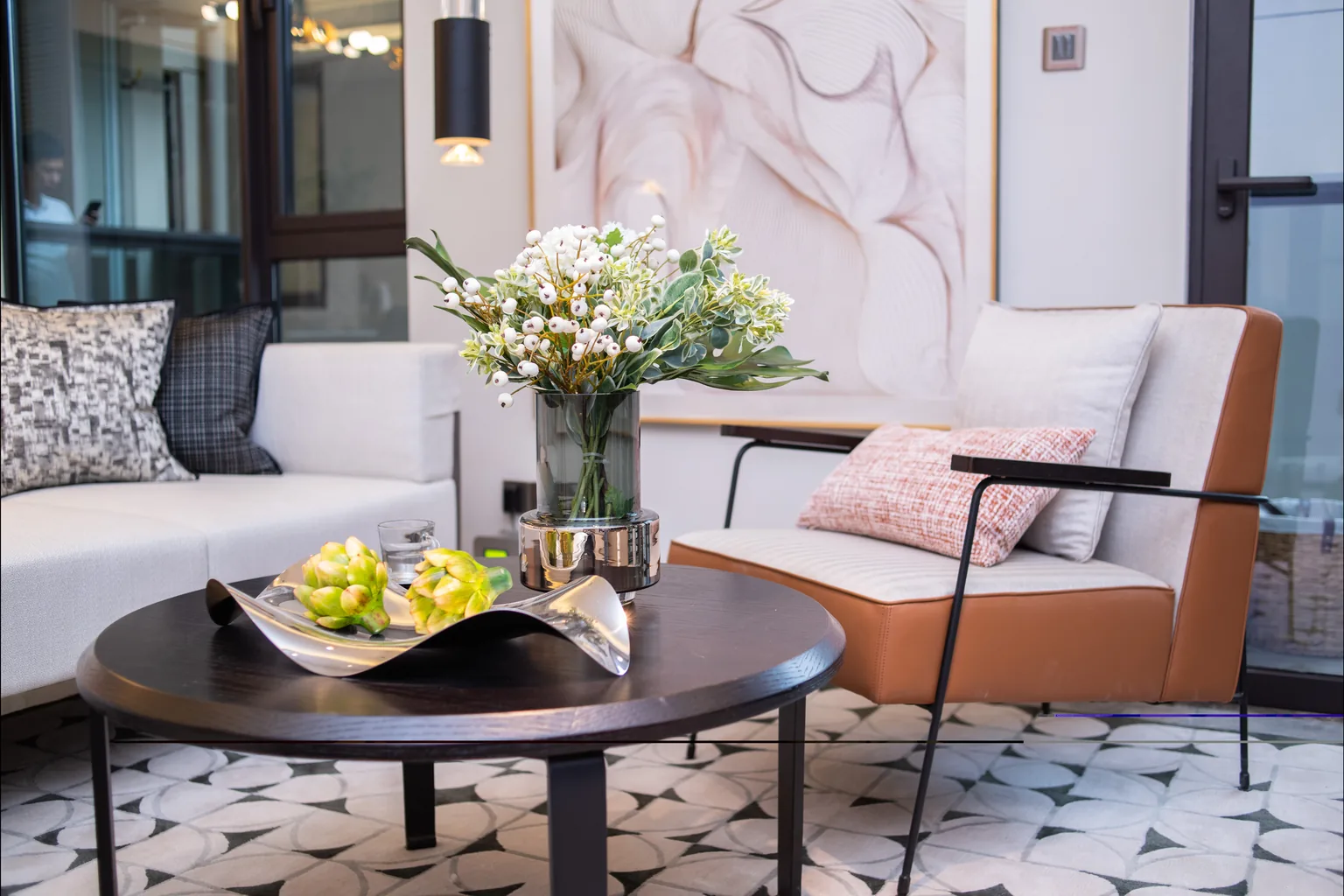 Refurbished living room seating area with fresh flowers and patterned floor tiles