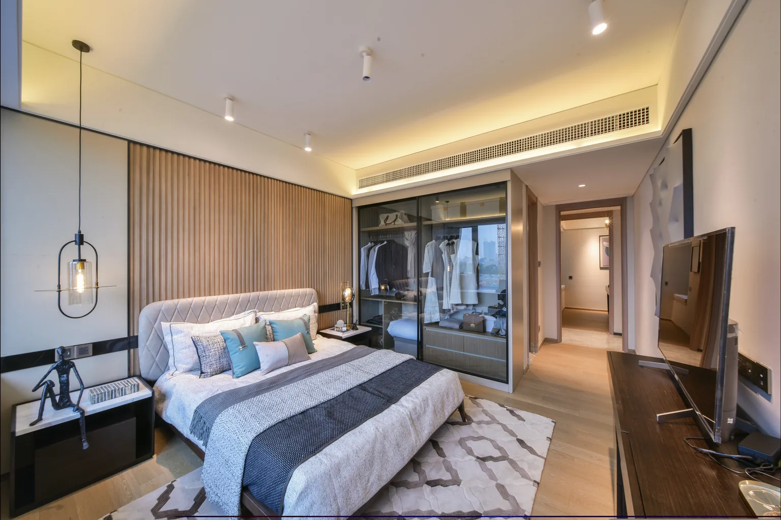 Bedroom with glass wardrobe, upholstered bed and warm lighting